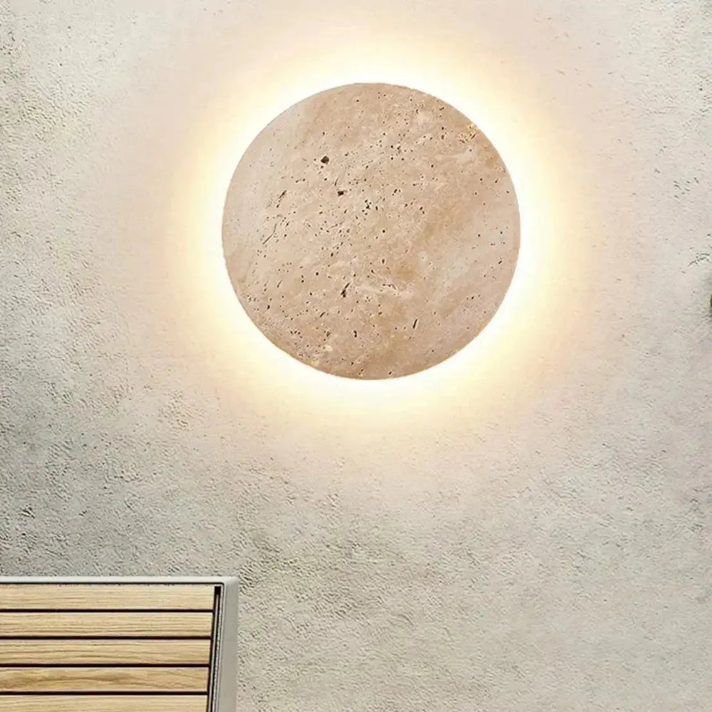 Zenvia Essentials Stone-Inspired Round Wall Lamp with smooth surface, turned on, on white wall