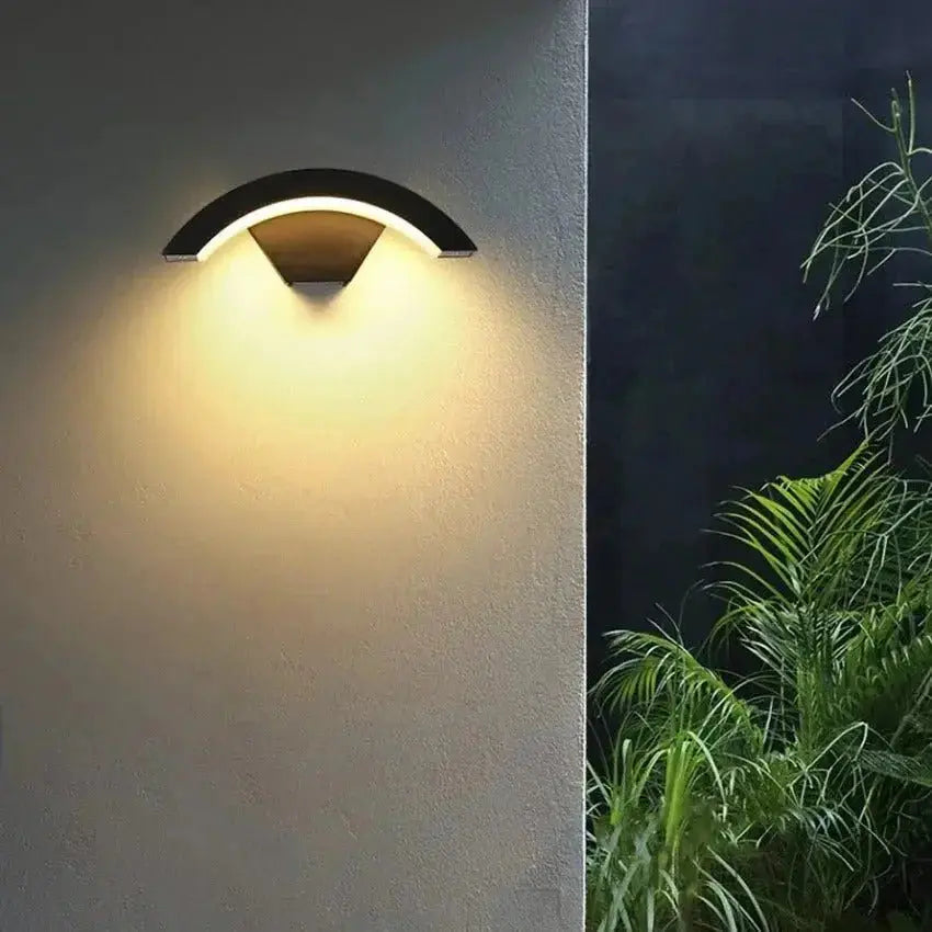 Zenvia Essentials Modern Curved LED Motion Sensor Wall Light on a gray wall with black base and yellow center
