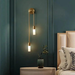 Zenvia Essentials Modern Gold LED Wall Lights Sconces with gold finish and white glass shades, mounted above a nightstand