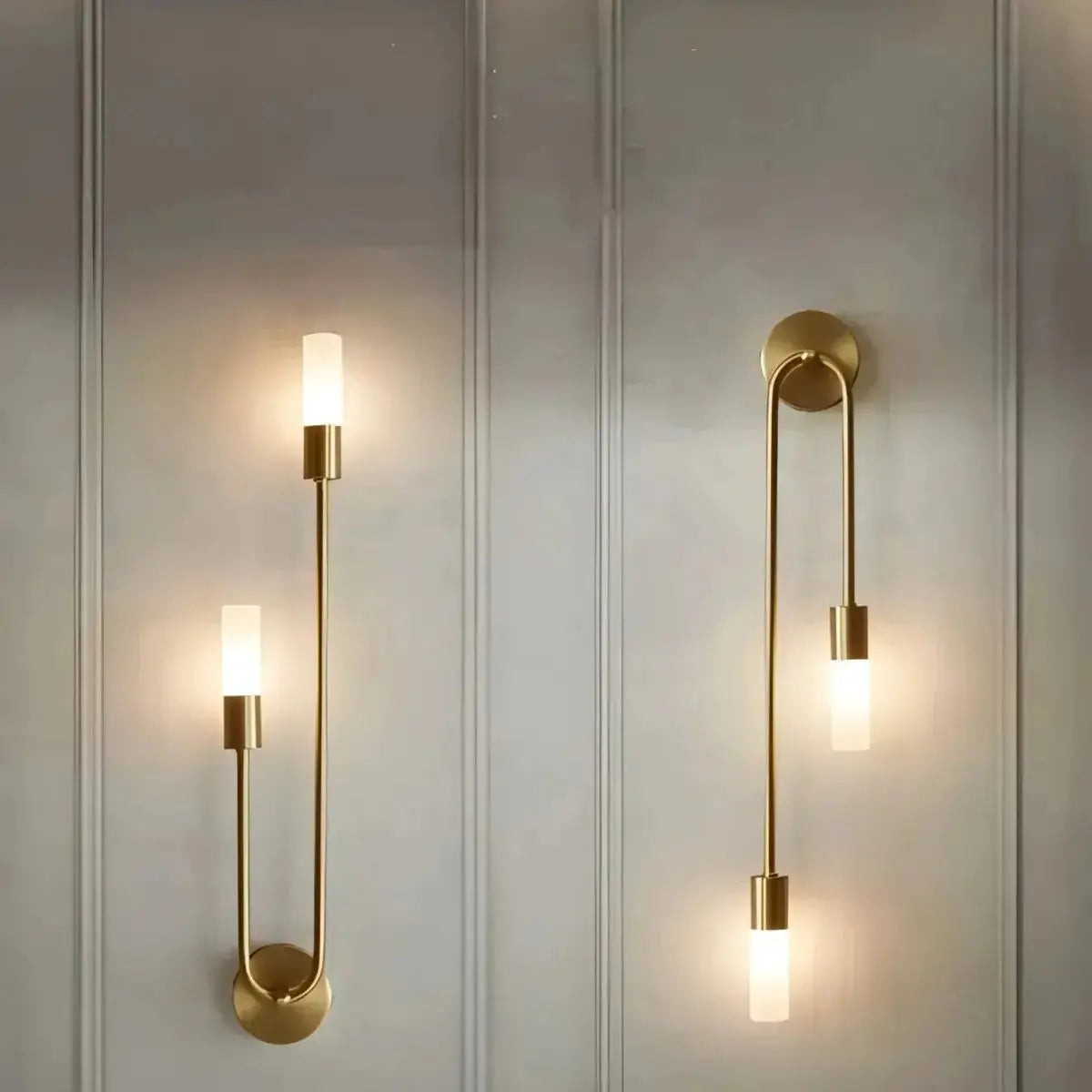 Zenvia Essentials Modern Gold LED Wall Lights Sconces, a pair of brass wall sconces with curved arm and round base on white wall