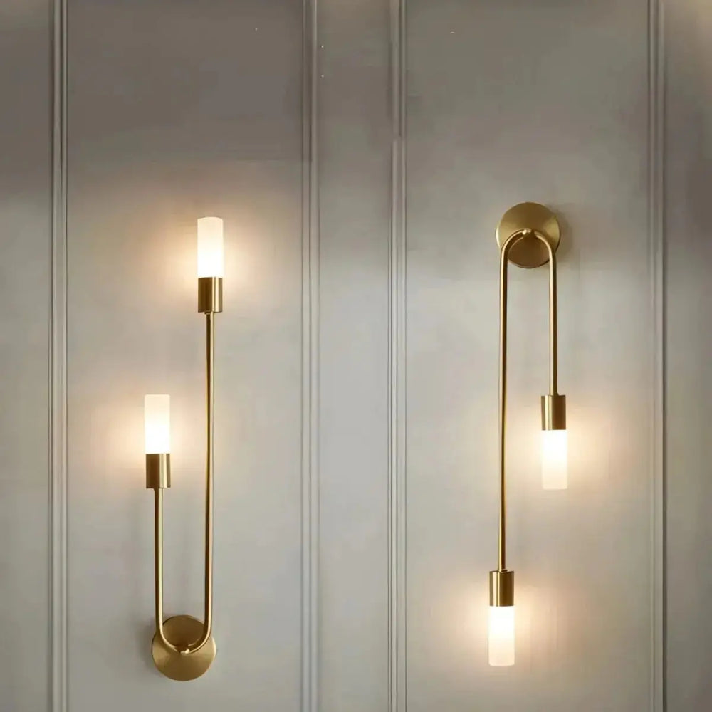 Zenvia Essentials Modern Gold LED Wall Lights Sconces, a pair of brass wall sconces with curved arm and round base on white wall