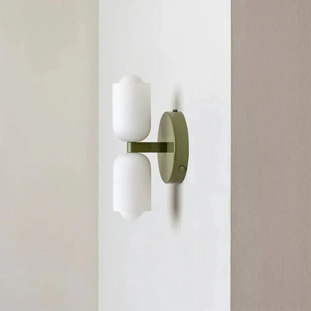 Zenvia Essentials Modern Up Down Acrylic Wall Light with white glass shades on a green metal bracket
