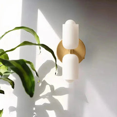 Zenvia Essentials Modern Up Down Acrylic Wall Light with white glass and gold metal on a white wall