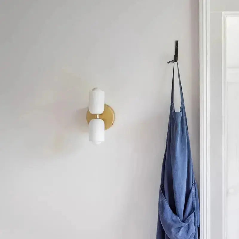 Zenvia Essentials Modern Up Down Acrylic Wall Light with gold details on a white wall