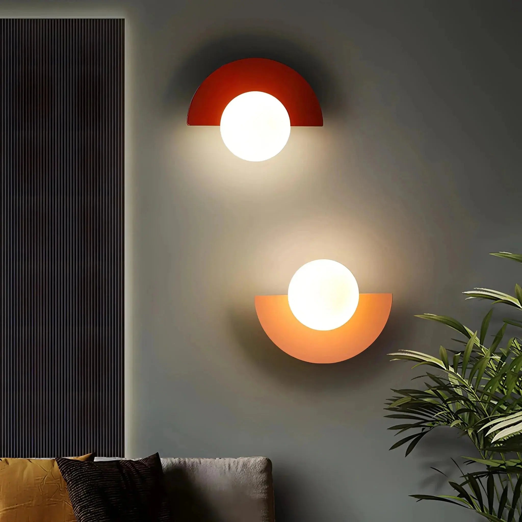 Two Nordic Semicircle Wall Lights by Zenvia Essentials on a gray wall, one red and one orange