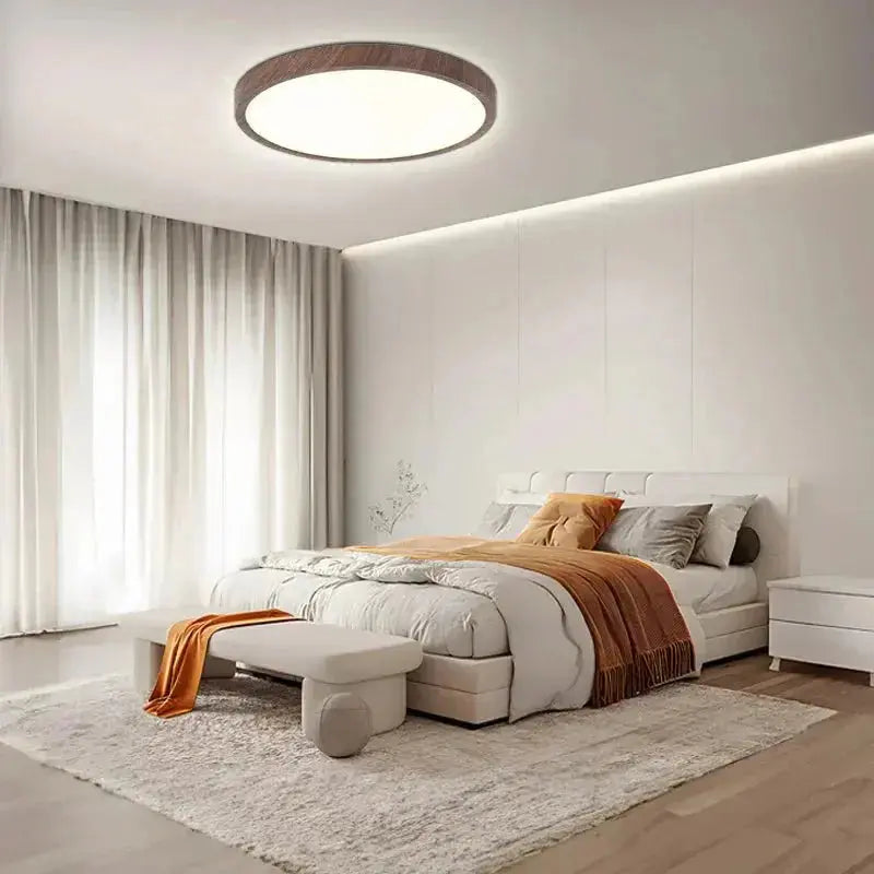Zenvia Essentials Ultrathin Circular Ceiling Light above a white bed in a modern bedroom.