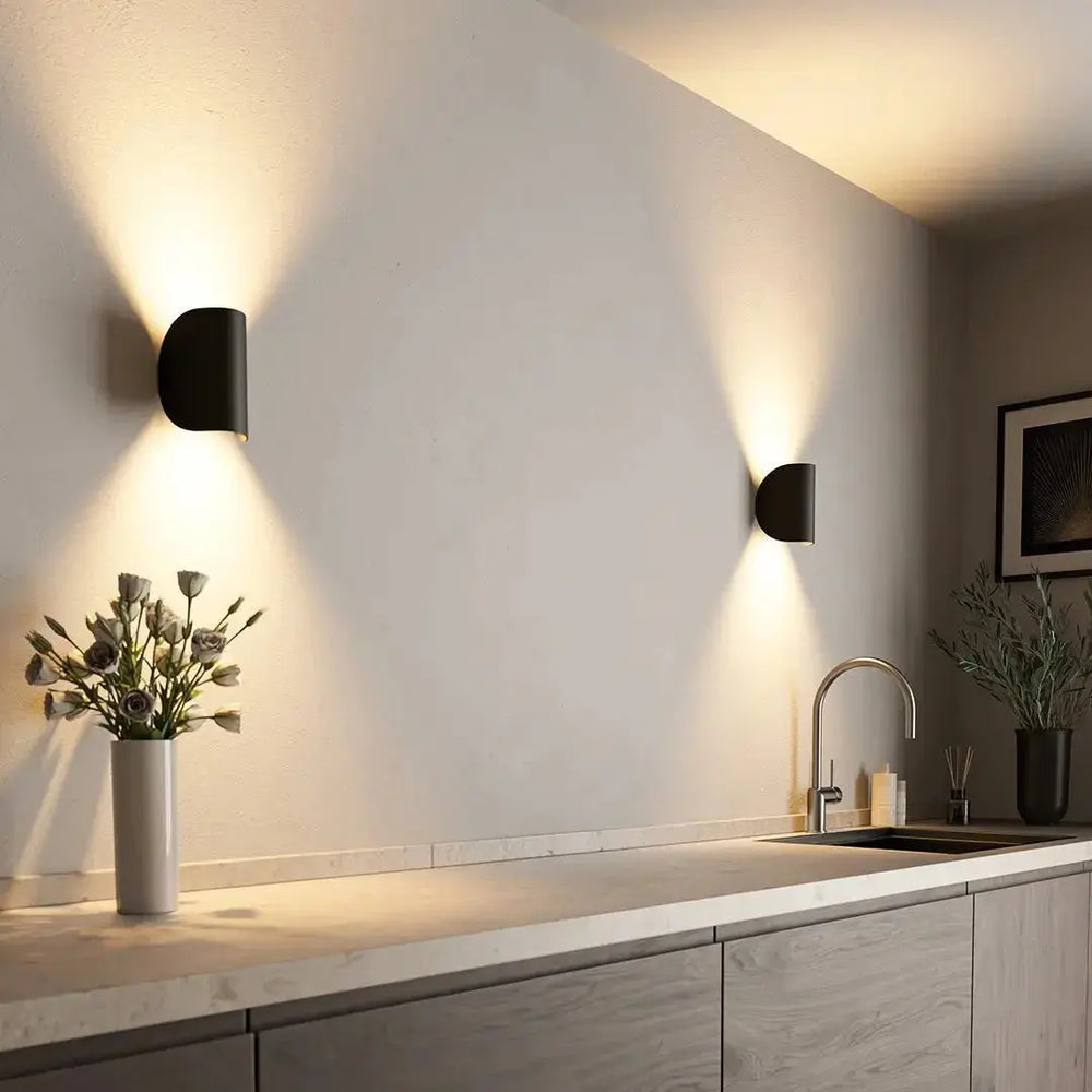 Up & Down Modern Wall Sconce Light by Zenvia Essentials mounted above a sink in a modern white kitchen.